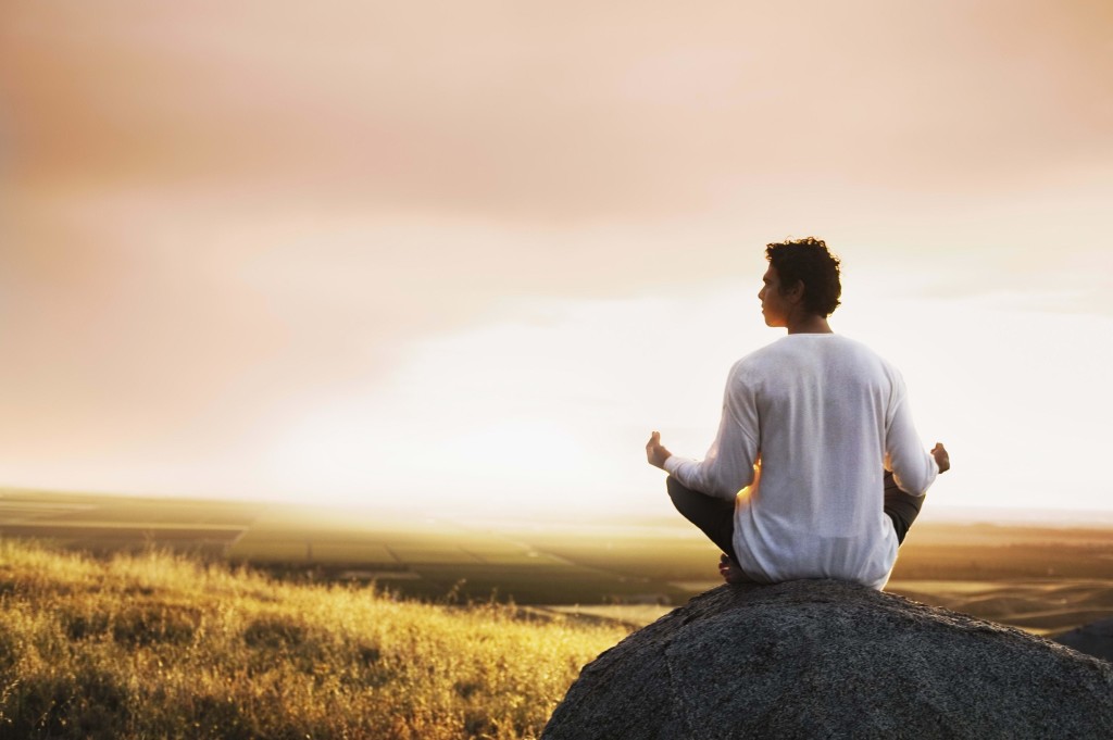 man-meditation-stone-field-morning